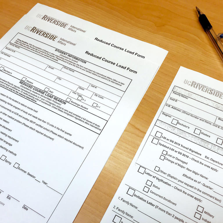 Reduced Course Load Form and Document Request Form laying on a table next to a pen